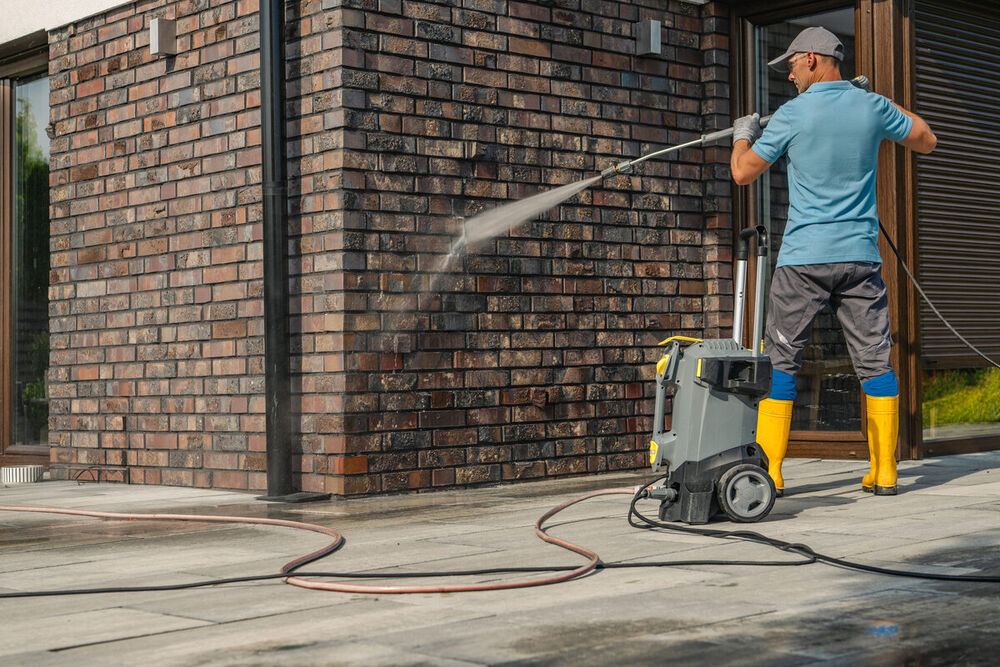 Pressure washing a brick home exterior